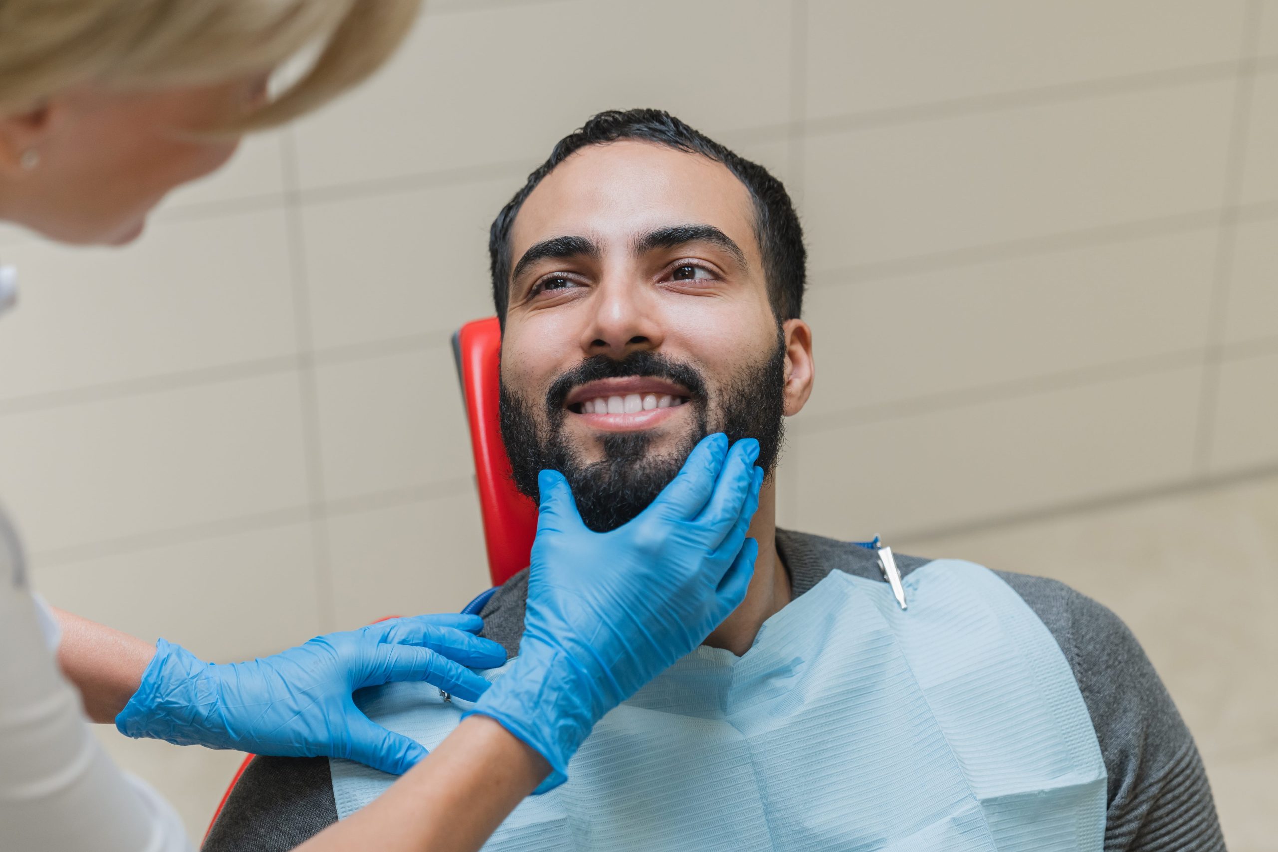 man with perfect smile visiting dentist after getting dental implants to help with gum disease